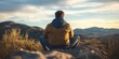 © StockUp - A man sits cross-legged on a rocky surface, meditating with a tranquil, scenic view of mountains under a setting sun.