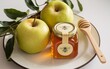 © BackgroundStudio - A jar of honey with a wooden spoon and two apples on a plate.