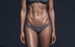 © BackgroundStudio - Closeup of a woman's toned abdomen in grey underwear against a dark background.