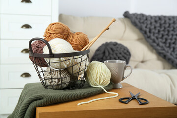 Wall Mural - Basket with yarns, knitting needles, scissors and sweater on coffee table indoors