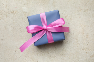 Beautiful gift box with pink bow on light grey table, top view