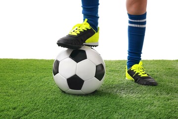 Wall Mural - Football player with soccer ball on artificial grass against white background, closeup