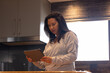 © Wavebreak Media - Senior woman using tablet in kitchen, focusing on screen, casual home setting