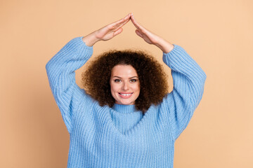 Wall Mural - Portrait photo of young beautiful chevelure hair lady in blue fall season trendy sweater protect herself with roof isolated on beige color background