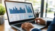 © muhammad - A person analyzing data on a laptop with various graphs and charts displayed.