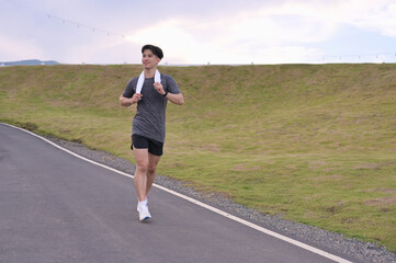 Smiling man enjoying a morning run in nature. Wellness and Healthy lifestyle concept