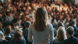 © Aysel - A woman is giving a presentation at a business conference. The audience is filled with people, but their faces are not clear. This event focuses on business and entrepreneurship.