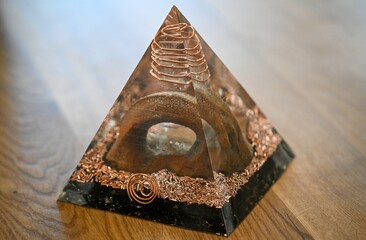 High resolution image of a single isolated beautiful one of a kind hand made Orgone pyramid generator containing crystals