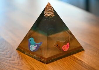 High resolution image of a single isolated beautiful one of a kind hand made Orgone pyramid generator containing crystals