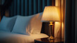 © 沈军 贡 - A close-up photo of the bedside table in an elegant hotel room, with a white pillow and lamp on it