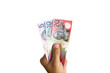 © Dadan - close up of man hand holding Australian dollar cash isolated on white background