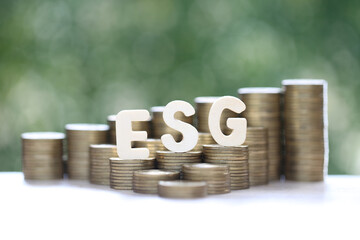 ESG (Environmental, Social and Governance words),ESG word on coins money on green background, investment and esg fund concept