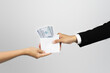 © Candra - businessman hand trying to give money bribe payment. someone who commits corruption by trying to give gratuities to his business partners. Corruption bribery concept.