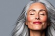 © Nataliia_Trushchenko - Woman with long gray hair is smiling and looking at the camera. She has red lipstick on and her eyes are closed