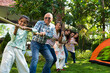 © StockImageFactory - Indian family of six enjoying a fun outdoor camping game of tug of war, bonding, creating memories