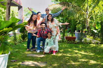 Indian family of six happily posing for a group photo during a camping trip, capturing cherished memories