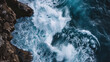 © Kosin - Powerful ocean waves crashing against rocky cliffs create stunning display of natures force and beauty. vibrant blue water contrasts with rugged rocks, evoking sense of awe and tranquility