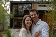 © Marcos - Joyful couple smiling, husband and wife, hugging in front of new modern home. Real estate buying moving new house concept