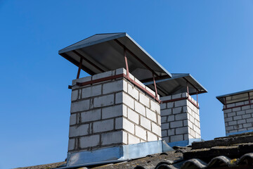 several brick chimneys covered with iron lids