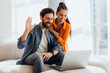 © Maria Vitkovska - Portrait of happy, smiling Hispanic couple using laptop, waving hand having video call