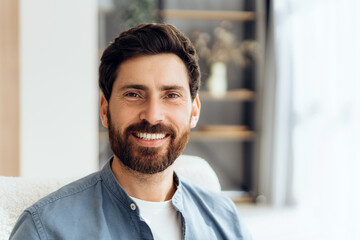 Portrait of handsome, smiling Latin man looking at camera posing at home dental care