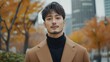 © chic designs - 色とりどりの葉が茂る秋の街並みの中で自信に満ちた若い男性