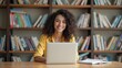 © Thierry - Student studying in a cozy library — A young woman with curly hair smiling as she works on her laptop in a cozy library filled with books.
