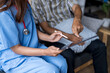 © Wasana - Doctor using digital tablet explaining medical test results to senior patient