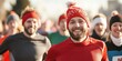 © Kamonwan - Cheerful runners wearing winter hats participating in a fun race outdoors.