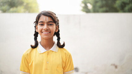 Indian schoolgirl sitting at desk in classroom, group of school kids with notebooks writing test, Education concept.