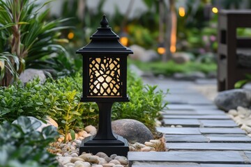 Wall Mural - Black metal lantern illuminating the stone path in a garden at night