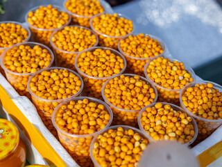 Wall Mural - Sea buckthorn berries in boxes on the market counter-autumn market. Autumn harvest time.