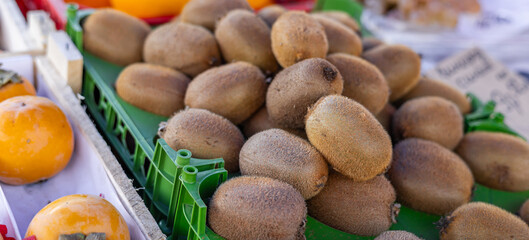 Wall Mural - Background of many kiwis. Close-up of a kiwi in full frame at the market. Store background. Healthy food. Images of vegetable products. Vegetarian food.