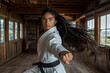 © antusher - Young martial artist in white karate, dynamic punch pose, cinematic lighting