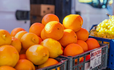 Wall Mural - Fresh mandarin oranges or tangerines fruit with leaves in boxes at the open air local food market. Wholesale depot of exotic fruits. Local produce at the farmers market.