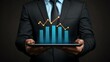 © AKE - Businessman holding tablet with financial growth chart.