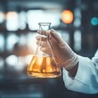 © Johannes - hand of scientist holding flask with lab glassware in chemical laboratory background, science laboratory research and development concept