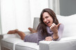 © Giulio_Fornasar - Young woman winking and pointing her thumb while relaxing on the