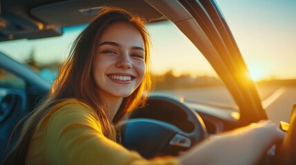 Canvas Print - A woman driving a car during sunset with the warm orange glow of the setting sun in the background