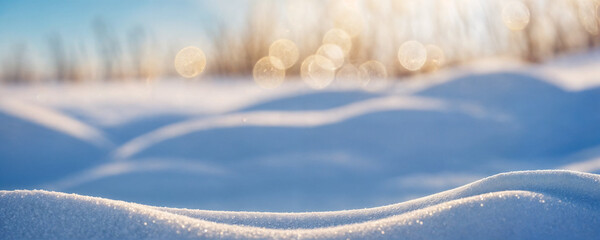 Winter snow background with snowdrifts, with beautiful light and snow flakes on the blue sky, beautiful bokeh circles, banner format, copy space.