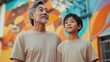 © Sasa Visual - A senior Asian man stands alongside a young Latino boy, both smiling in front of a colorful mural