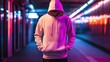 © Sasa Visual - An individual stands confidently in a trendy hoodie, surrounded by colorful neon lights at night