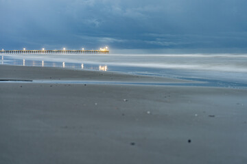 Serene Beach and Pier Under a Cloudy Sky