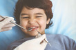 © Iryna - Cute arab boy sitting at dental chair with open mouth during oral checking up with doctor. Visiting sunny dentist office