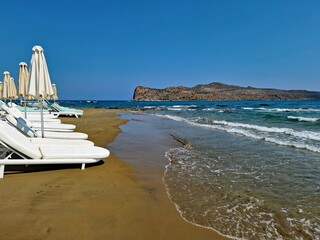 Luxury white sunbeds on the beach in the resort of Agia Marina in Crete. Greece, Europe.