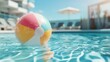 © Dulemegapixel - A bright, multicolored beach ball floats atop a sparkling blue pool on a sunny day, with blurred lounge chairs and an umbrella in the background.