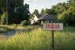 © AIPhoto - Abandoned house with overgrown grass and weathered sign indicating LIV. ON. scene evokes sense of neglect and passage of time, surrounded by nature reclaiming space