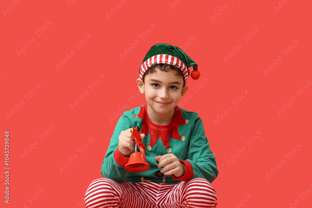 Cute little elf with Christmas bell on red background
