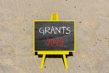 Planning grants 2025 new year symbol. Concept words Grants 2025 on beautiful yellow chalk blackboard. Beautiful sand beach background. Business grants 2025 new year concept. Copy space.