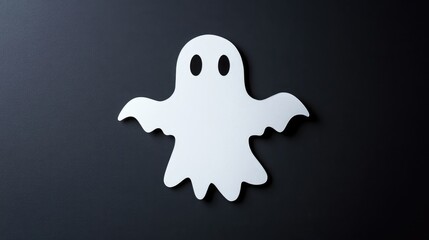 A white ghost shape cut out from paper, mounted on a black wall for a simple yet striking Halloween decor